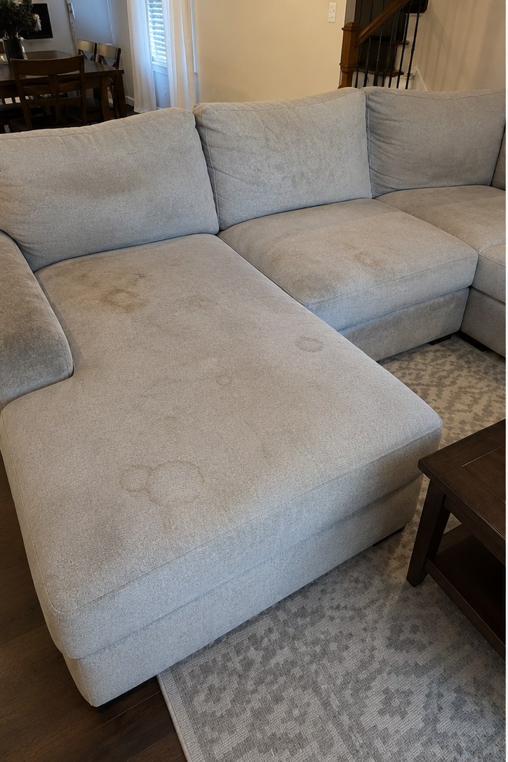 Before: Light-gray microfiber sectional in a Rossview home — food and body-oil staining removed with low-moisture upholstery cleaning. Dry to sit on in about 4 hours.